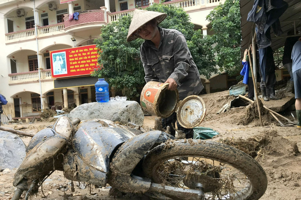 Người dân khối 1, thị trấn Mường Xén, Kỳ Sơn (Nghệ An), cố gắng tìm kiếm những tài sản còn sót lại sau trận lũ quét. (Ảnh: Văn Tý/TTXVN)