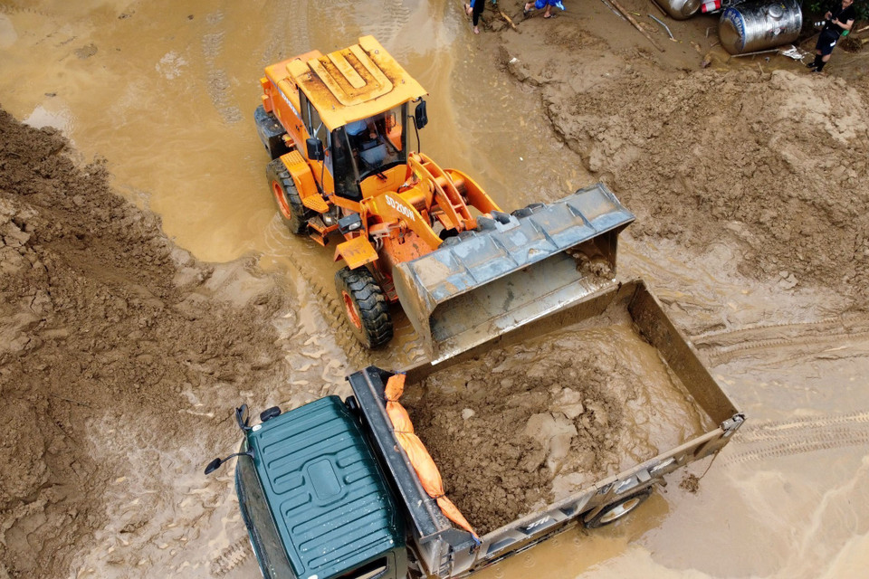 Chính quyền địa phương cùng người dân đang huy động tối đa máy móc, nhân lực khắc phục hậu quả do trận lũ quét gây ra tại huyện Kỳ Sơn, tỉnh Nghệ An. (Ảnh: TTXVN phát) 