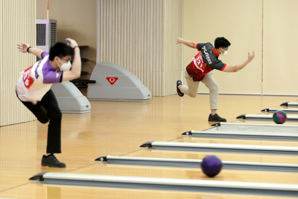 Vận động viên Philippines (bên trái) và vận động viên Singapore thực hiện những lần ném đầu tiên. (Ảnh: Trung Kiên/TTXVN)