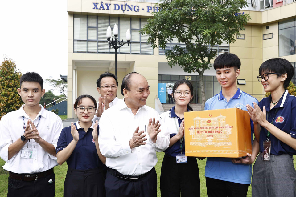 Chủ tịch nước Nguyễn Xuân Phúc tặng quà cho sinh viên Đại học Quốc gia Thành phố Hồ Chí Minh. (Ảnh: Thống Nhất/TTXVN)