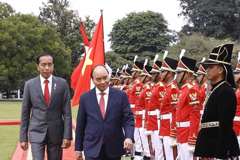 Chủ tịch nước Nguyễn Xuân Phúc và Tổng thống nước Cộng hòa Indonesia Joko Widodo duyệt đội danh dự. (Ảnh: Thống Nhất/TTXVN)