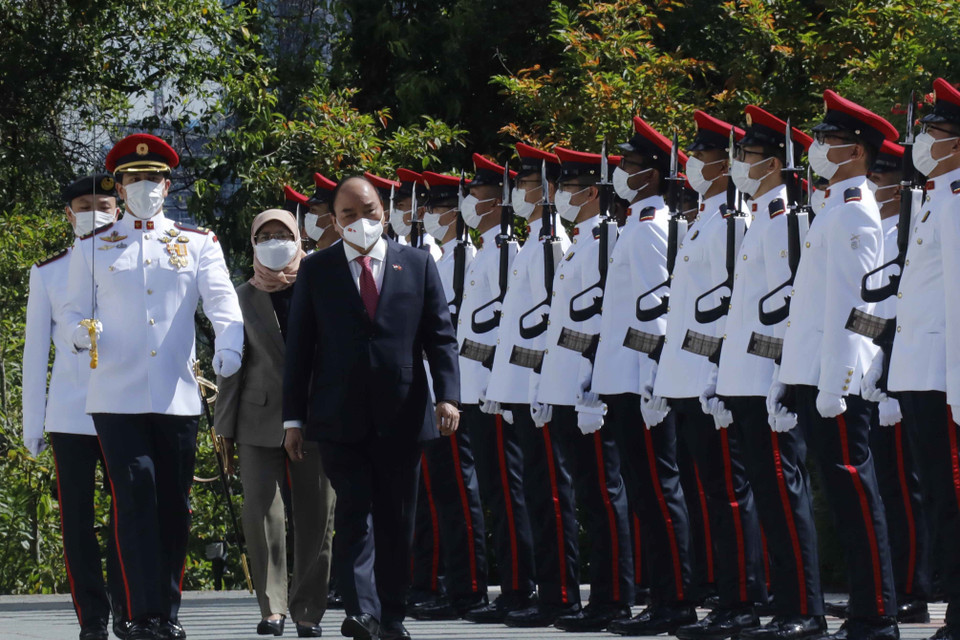 Chủ tịch nước Nguyễn Xuân Phúc và Tổng thống Cộng hòa Singapore Halimah Yacob duyệt đội danh dự. (Ảnh: Thống Nhất/TTXVN)