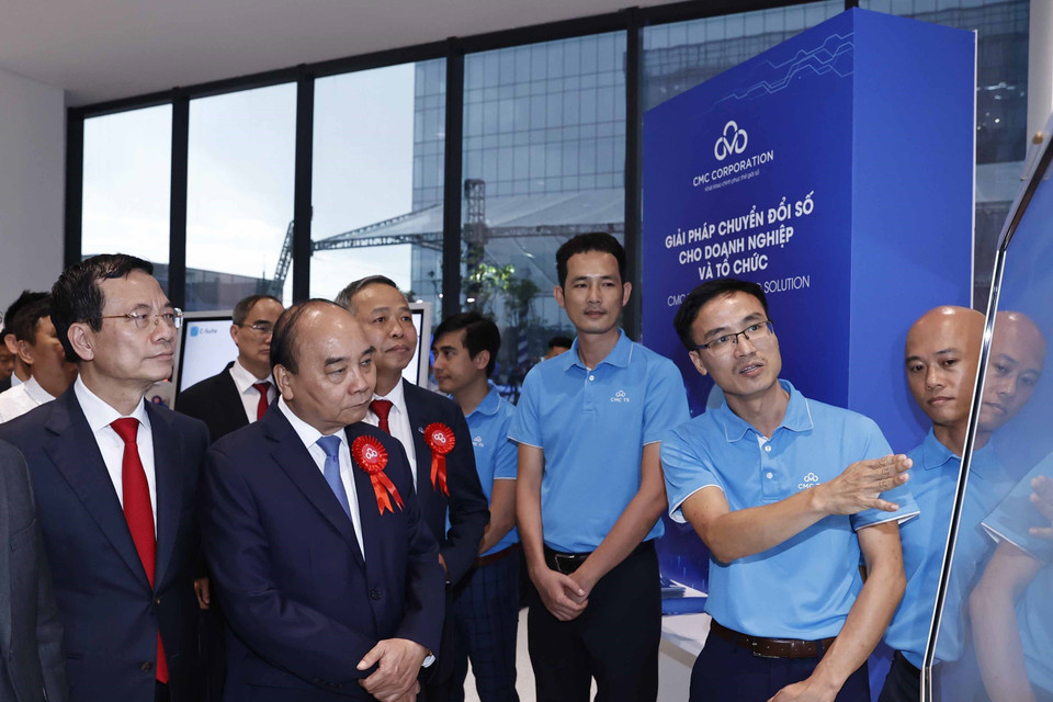 Chủ tịch nước Nguyễn Xuân Phúc và các đại biểu tham quan trưng bày, giới thiệu về các sản phẩm dữ liệu. (Ảnh: Thống Nhất/TTXVN)