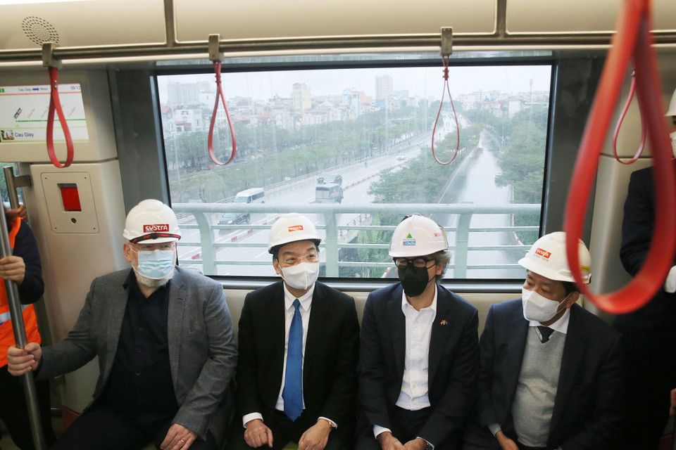 Phó Chủ tịch điều hành Ủy ban Châu Âu (EC) Frans Timmermans và Chủ tịch UBND thành phố Hà Nội Chu Ngọc Anh trên tàu di chuyển từ ga Cầu Giấy đi depot Nhổn. (Ảnh: Lâm Khánh/TTXVN)