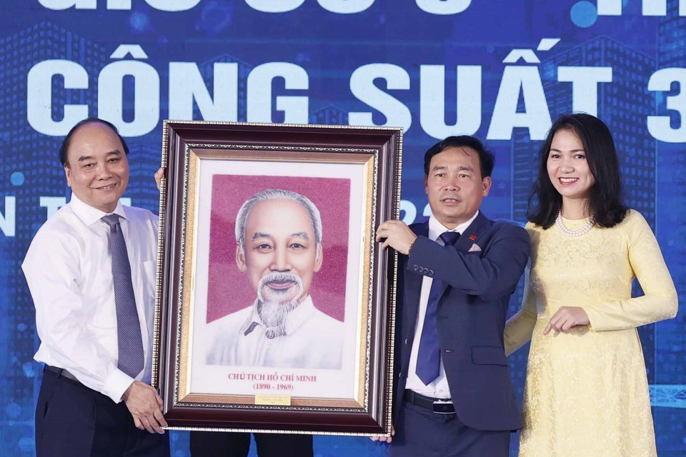 Chủ tịch nước Nguyễn Xuân Phúc tặng ảnh chân dung Chủ tịch Hồ Chí Minh cho Công ty Cổ phần Tân Hoàn Cầu, Bến Tre. (Ảnh: Thống Nhất/TTXVN)