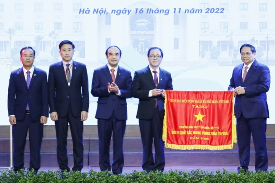 Thủ tướng Phạm Minh Chính trao Cờ thi đua của Chính phủ cho Trường Đại học Y Hà Nội. (Ảnh: Dương Giang/TTXVN)