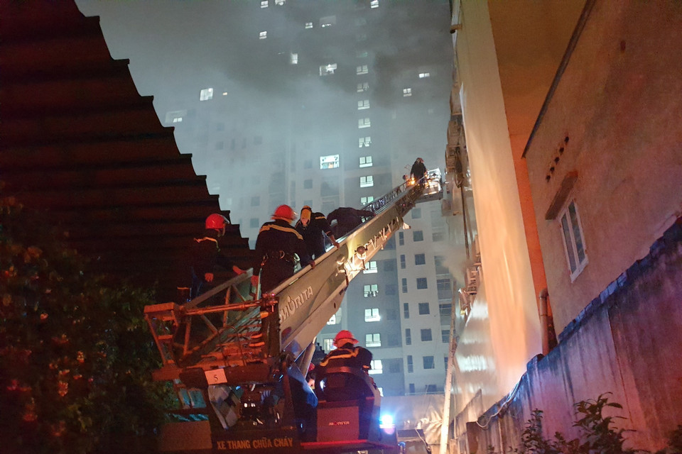 Hình ảnh lực lượng chức năng đang giải cứu nhiều người mắc kẹt trong vụ cháy. (Ảnh: TTXVN phát)