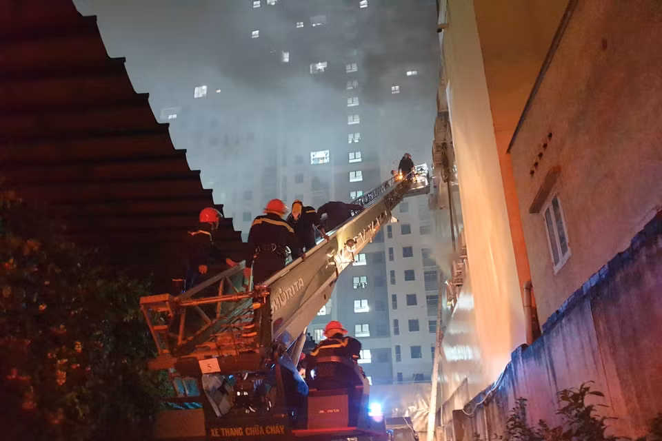 Hình ảnh lực lượng chức năng đang giải cứu nhiều người mắc kẹt trong vụ cháy. (Ảnh: TTXVN phát)