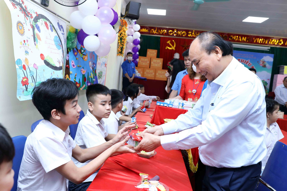 Chủ tịch nước Nguyễn Xuân Phúc tặng quà cho trẻ khuyết tật. (Ảnh An Đăng/TTXVN)