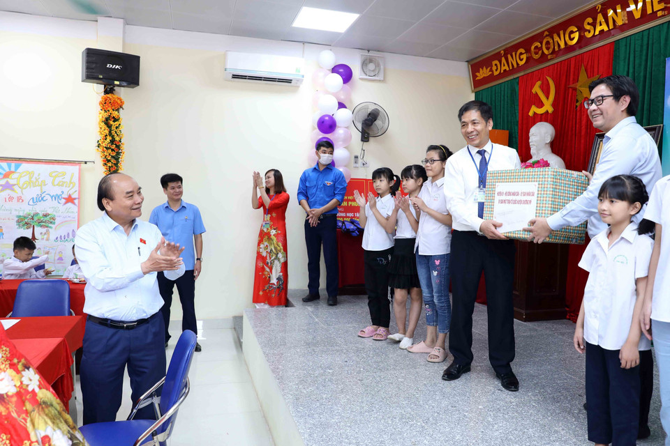 Chủ tịch nước Nguyễn Xuân Phúc chứng kiến các đơn vị tặng quà cho Trung tâm Nuôi dưỡng trẻ khuyết tật Hà Nội. (Ảnh An Đăng/TTXVN)