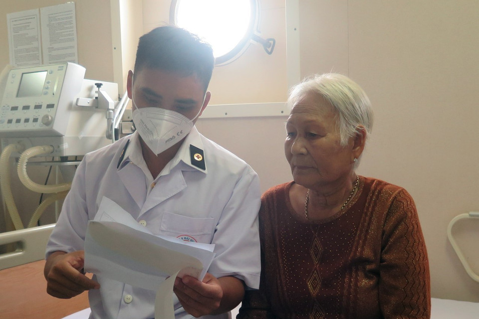 Bác sỹ trên tàu bệnh viện Khánh Hòa 01 ân cần dặn dò bệnh nhân. (Ảnh: Xuân Triệu/TTXVN)