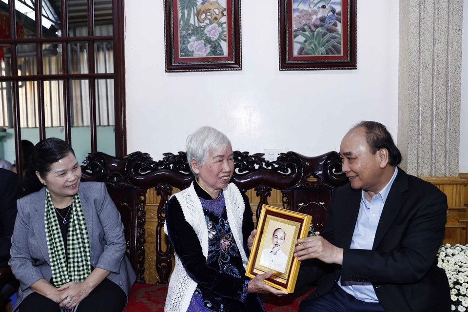 Chủ tịch nước Nguyễn Xuân Phúc thăm và tặng quà bà Đinh Thị Huệ, vợ liệt sỹ ở tổ dân phố số 5, phường Tân Phong, thành phố Lai Châu. (Ảnh: Thống Nhất/TTXVN)