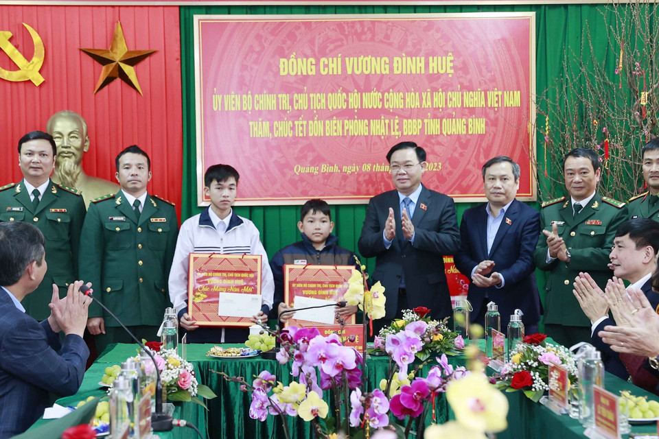 Chủ tịch Quốc hội Vương Đình Huệ tặng quà cho 2 cháu bé mồ côi được Đồn Biên phòng Nhật Lệ, Quảng Bình nuôi dưỡng. (Ảnh: Doãn Tấn/TTXVN)