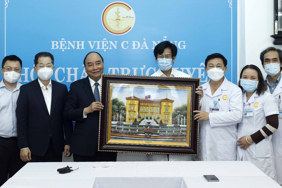 Chủ tịch nước Nguyễn Xuân Phúc tặng bức ảnh Khu Di tích Phủ Chủ tịch cho các y, bác sỹ tại Bệnh viện C Đà Nẵng. (Ảnh: Thống Nhất/TTXVN)