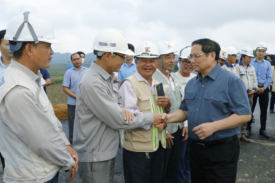 Thủ tướng Phạm Minh Chính động viên công nhân xây dựng dự án tuyến đường Đông-Tây giai đoạn 1, đoạn từ thành phố Tam Điệp đến huyện Nho Quan. (Ảnh: Dương Giang/TTXVN)