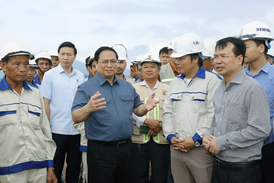 Thủ tướng Phạm Minh Chính nói chuyện với công nhân xây dựng dự án tuyến đường Đông-Tây giai đoạn 1 đoạn từ thành phố Tam Điệp đến huyện Nho Quan. (Ảnh: Dương Giang/TTXVN)