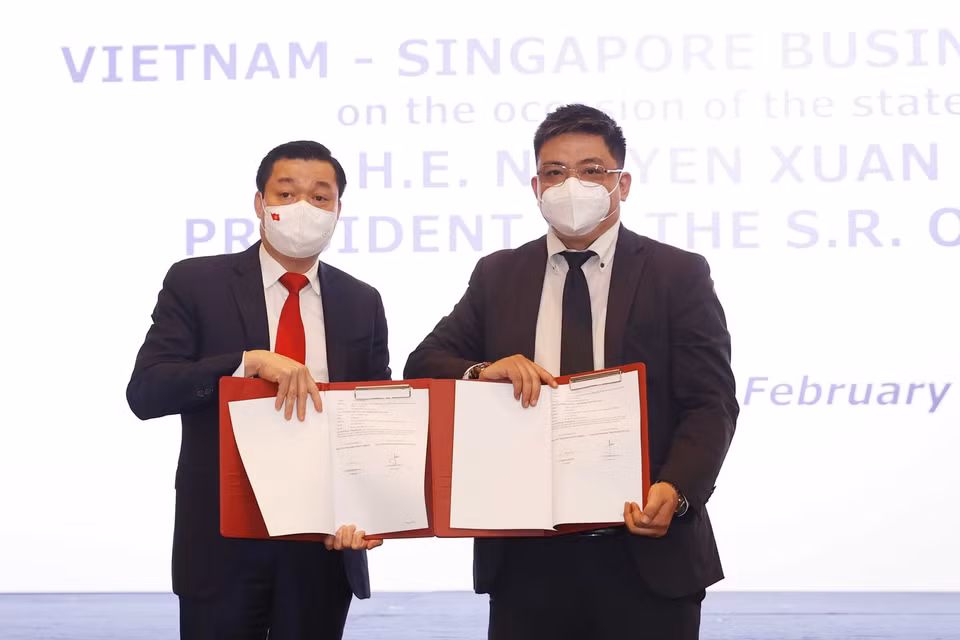 Doanh nghiệp hai nước trao đổi các hợp đồng, thỏa thuận hợp tác tại cuộc Đối thoại doanh nghiệp Việt Nam-Singapore. (Ảnh: Thống Nhất/TTXVN)