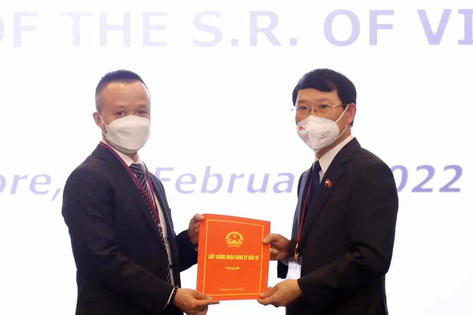 Chủ tịch UBND tỉnh Bắc Giang Lê Ánh Dương (bên phải) trao Giấy chứng nhận đăng ký đầu tư vào tỉnh Bắc Giang cho nhà đầu tư Singapore. (Ảnh: Thống Nhất/TTXVN) 