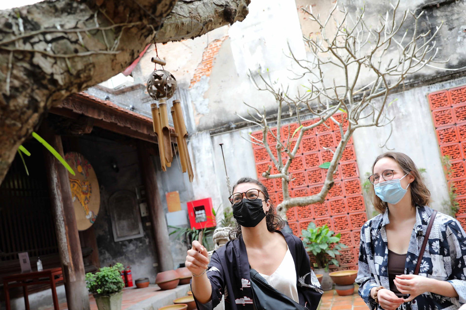 Du khách quốc tế tìm hiểu văn hóa Việt Nam khi tham quan đình Kim Ngân, quận Hoàn Kiếm. (Ảnh: Thanh Tùng/TTXVN)