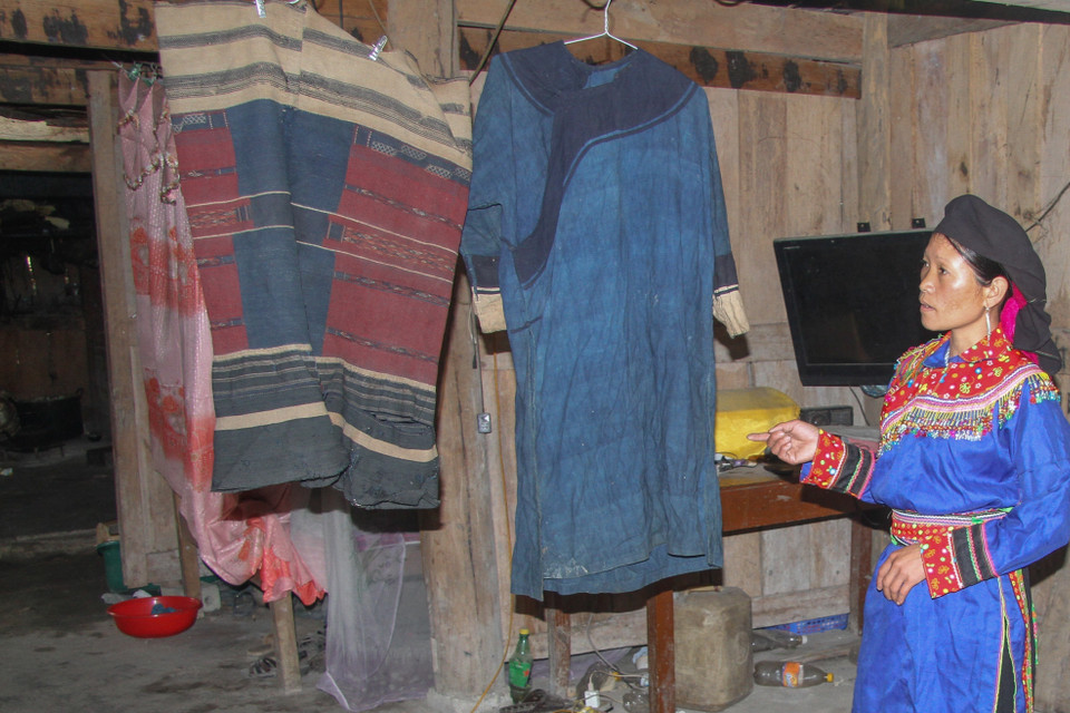 Hình ảnh Chị Min Thị Nguyệt giới thiệu về bộ váy áo cổ đã được lưu truyền 16 đời của người Cờ Lao đỏ. (Ảnh: Nam Thái/TTXVN)