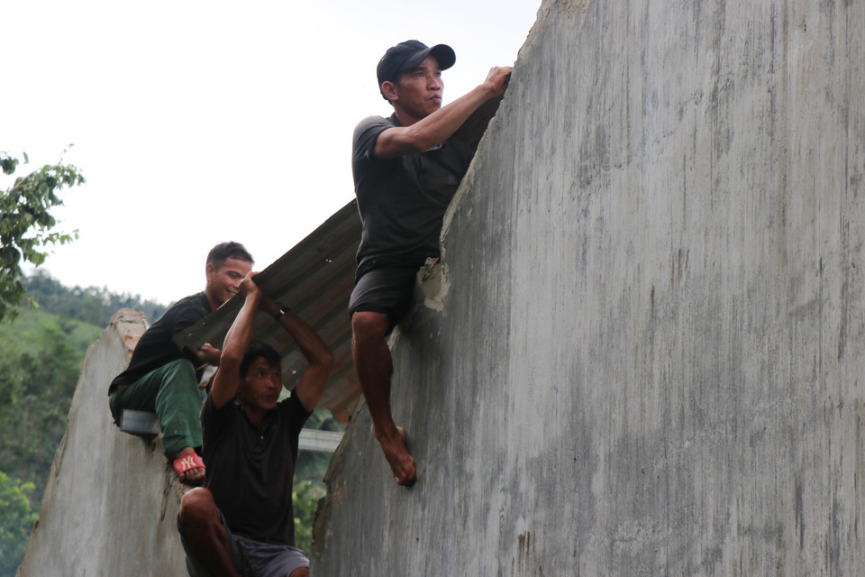 Ngay sau bão tan, người dân làng thôn Bờ Reo đã đến hỗ trợ gia đình anh Vuối lợp lại mái nhà. (Ảnh: Phạm Cường/TTXVN)