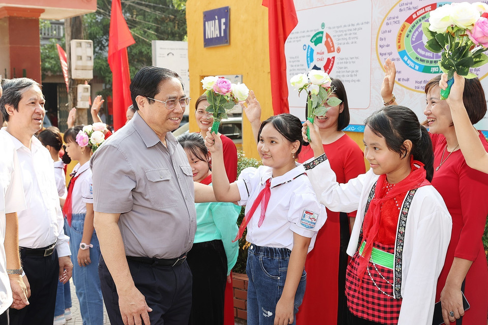 Thủ tướng Phạm Minh Chính và các em học sinh Trường Tiểu học thị trấn Yên Lập, huyện Yên Lập. (Ảnh: Dương Giang/TTXVN)