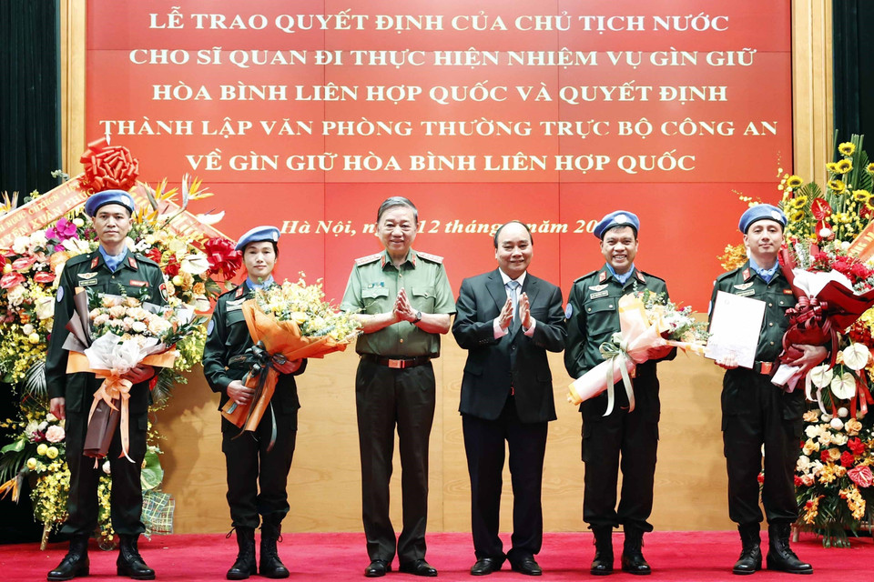 Chủ tịch nước Nguyễn Xuân Phúc trao Quyết định cho Trung tá Nguyễn Ngọc Hải làm nhiệm vụ tại Trụ sở Liên hợp quốc và tặng hoa cho 3 đồng chí đi thực hiện nhiệm vụ tại Phái bộ Liên hợp quốc ở Nam Sudan. (Ảnh: Thống Nhất/TTXVN)