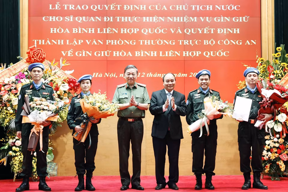 Chủ tịch nước Nguyễn Xuân Phúc trao Quyết định cho Trung tá Nguyễn Ngọc Hải làm nhiệm vụ tại Trụ sở Liên hợp quốc và tặng hoa cho 3 đồng chí đi thực hiện nhiệm vụ tại Phái bộ Liên hợp quốc ở Nam Sudan. (Ảnh: Thống Nhất/TTXVN)