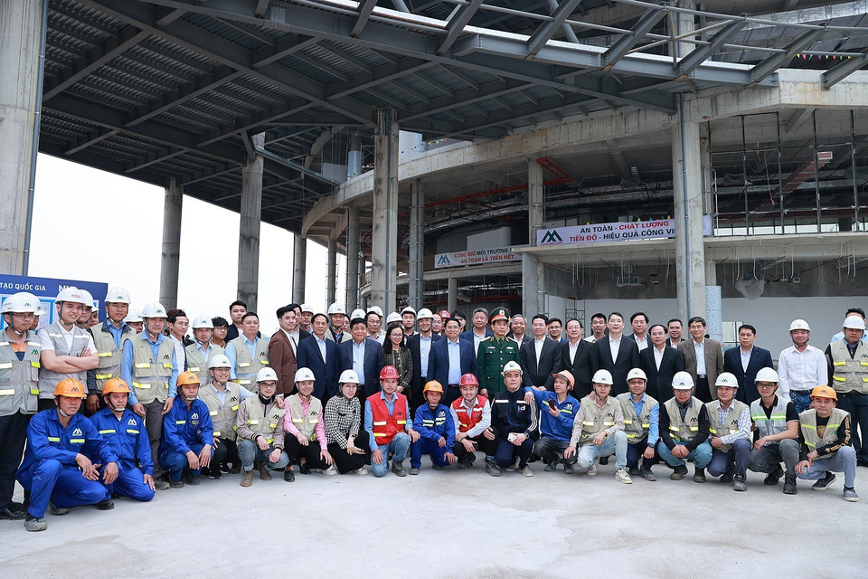 Thủ tướng Phạm Minh Chính với công nhân thi công dự án Trung tâm Đổi mới sáng tạo Quốc gia tại Khu Công nghệ cao Hòa Lạc. (Ảnh: Dương Giang/TTXVN)