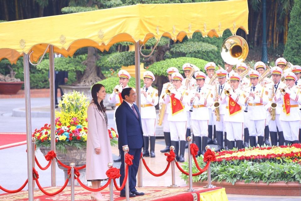 Thủ tướng Phạm Minh Chính và Thủ tướng New Zealand Jacinda Ardern thực hiện nghi lễ chào cờ khi dàn quân nhạc cử quốc thiều hai nước. (Ảnh: Văn Điệp/TTXVN)