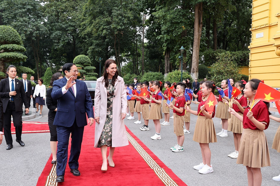 Thủ tướng Phạm Minh Chính và Thủ tướng New Zealand Jacinda Ardern với thiếu nhi Thủ đô. (Ảnh: Dương Giang/TTXVN)