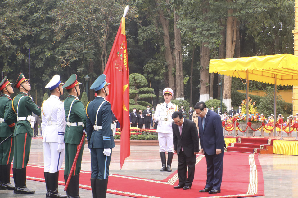 Thủ tướng Phạm Minh Chính và Thủ tướng Lào Phankham Viphavanh chào Quân kỳ Quyết thắng của Quân đội nhân dân Việt Nam. (Ảnh: Lâm Khánh/TTXVN)