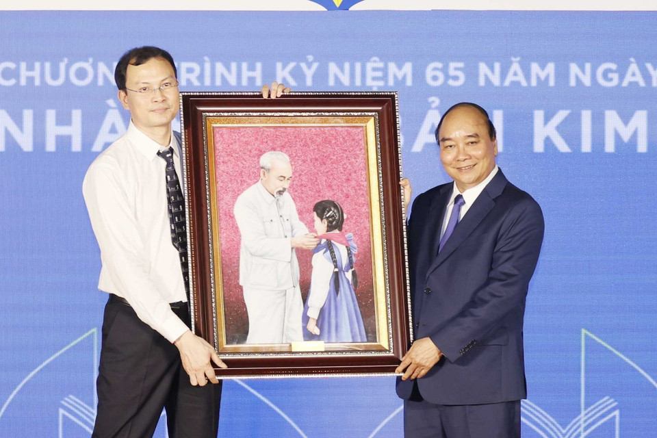 Chủ tịch nước Nguyễn Xuân Phúc tặng bức ảnh Bác Hồ với thiếu nhi cho Nhà xuất bản Kim Đồng. (Ảnh: Thống Nhất/TTXVN)