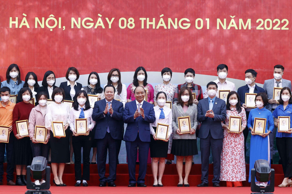 Chủ tịch nước Nguyễn Xuân Phúc tặng ảnh chân dung Chủ tịch Hồ Chí Minh cho các cá nhân có thành tích xuất sắc của Tập đoàn Dệt may Việt Nam. (Ảnh: Thống Nhất/TTXVN)