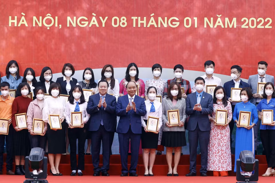Chủ tịch nước Nguyễn Xuân Phúc tặng ảnh chân dung Chủ tịch Hồ Chí Minh cho các cá nhân có thành tích xuất sắc của Tập đoàn Dệt may Việt Nam. (Ảnh: Thống Nhất/TTXVN)