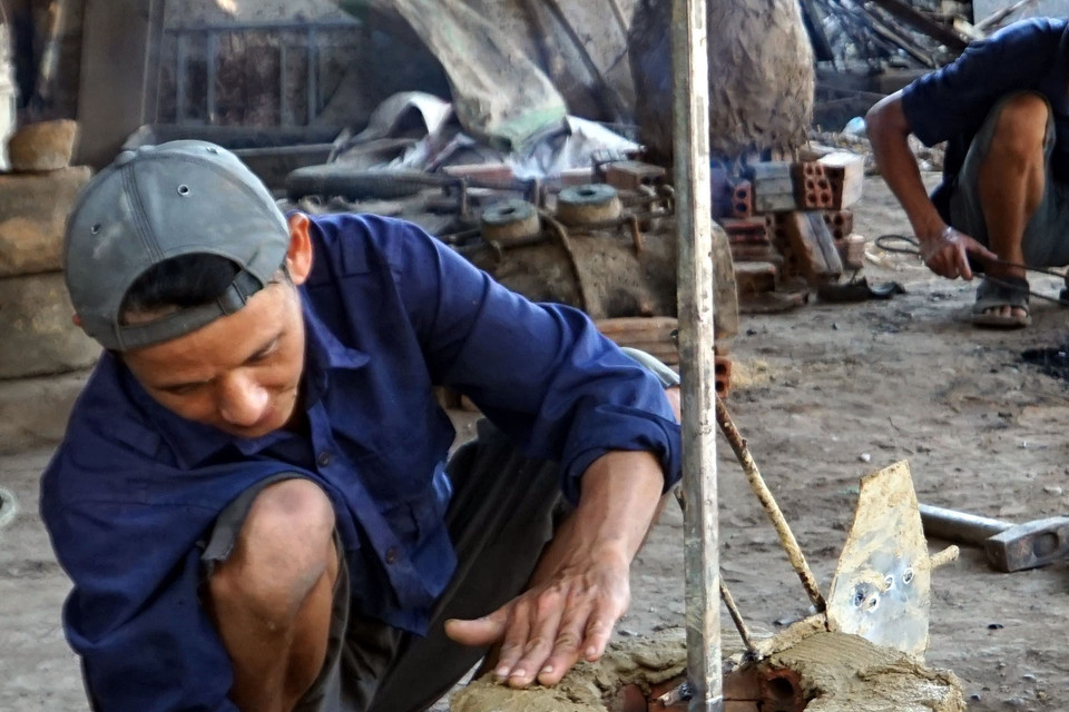 Thợ đúc đồng đang làm khuôn đúc. (Ảnh: Phước Tuệ/TTXVN) 