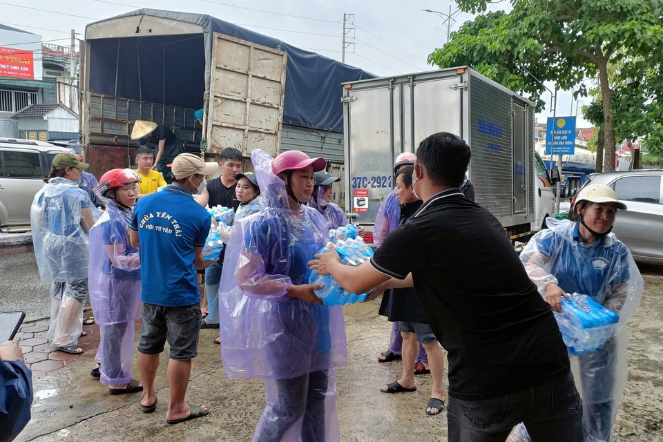 Lực lượng chức năng vận chuyển nước uống hỗ trợ người dân vùng bị ngập tại huyện Quỳnh Lưu (Nghệ An). (Ảnh: Tá Chuyên/TTXVN)
