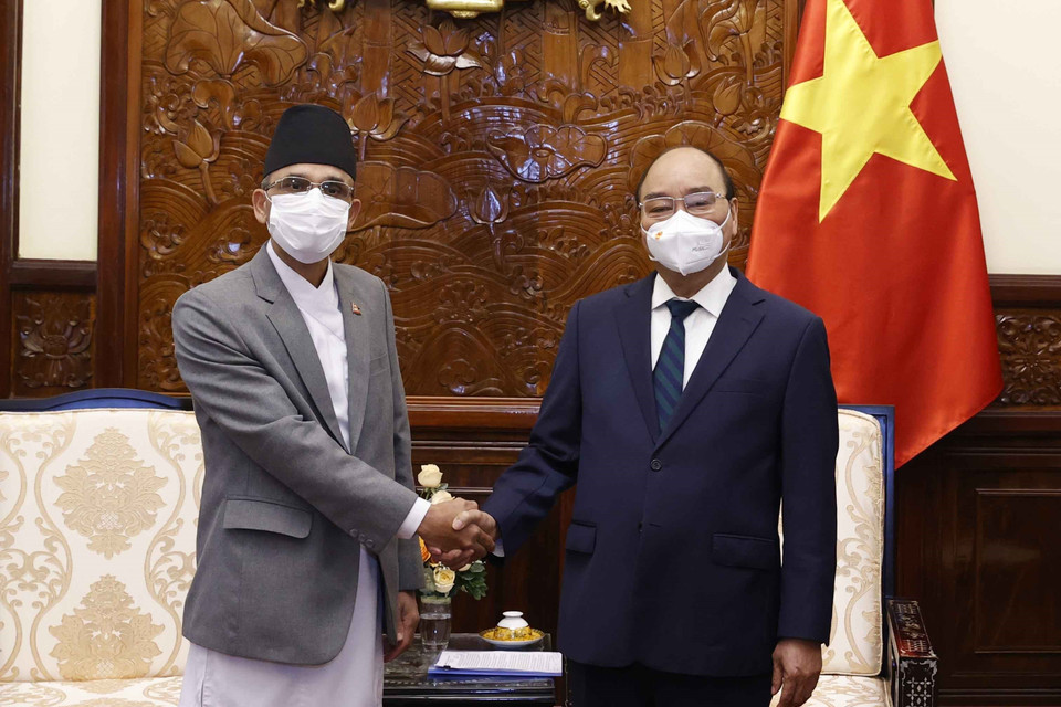 Chủ tịch nước Nguyễn Xuân Phúc chụp ảnh chung với Đại sứ Nepal Ganesh Prasad Dhakal. (Ảnh: Thống Nhất/TTXVN)