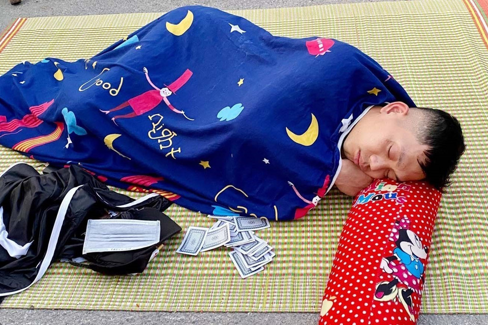 Cổ động viên có giấc ngủ ngon khi nằm chờ phát vé xem trận chung kết giữa Việt Nam-Thái Lan. (Ảnh: Thanh Vân/TTXVN)