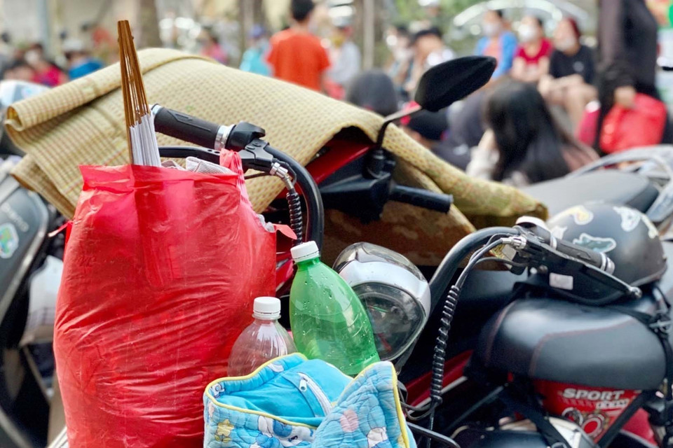 Người dân chuẩn bị sẵn đồ ăn, chiếu nằm chờ sẵn từ tối 20/5 để nhận vé mời xem trận chung kết bóng đá nữ Việt Nan gặp Thái Lan. (Ảnh: Thanh Vân/TTXVN) 