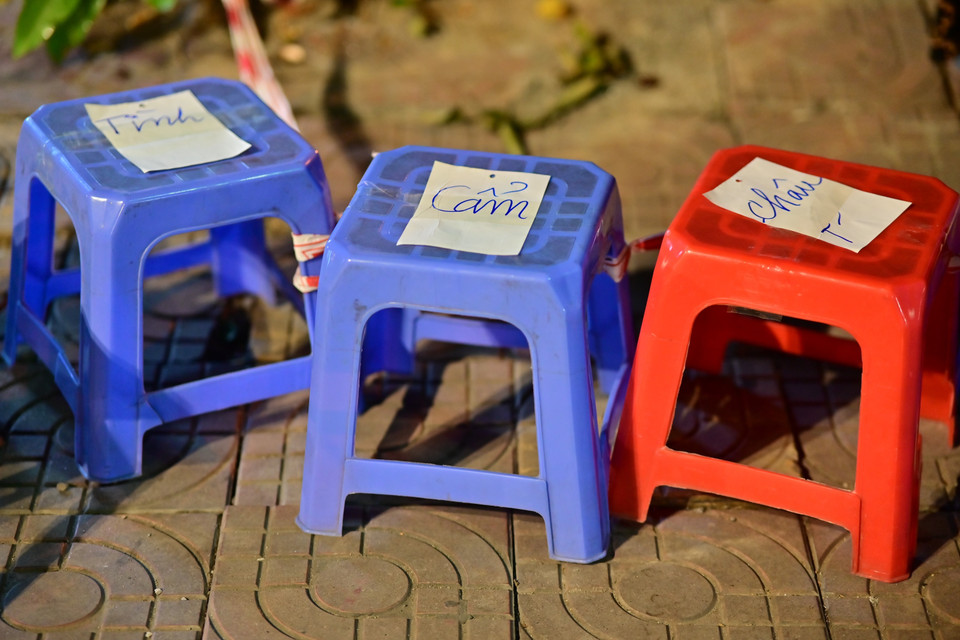 Nhiều người không đứng đợi được nên đã ghi tên lên ghế để giữ chỗ nhận vé. (Ảnh: Thanh Vân/TTXVN)