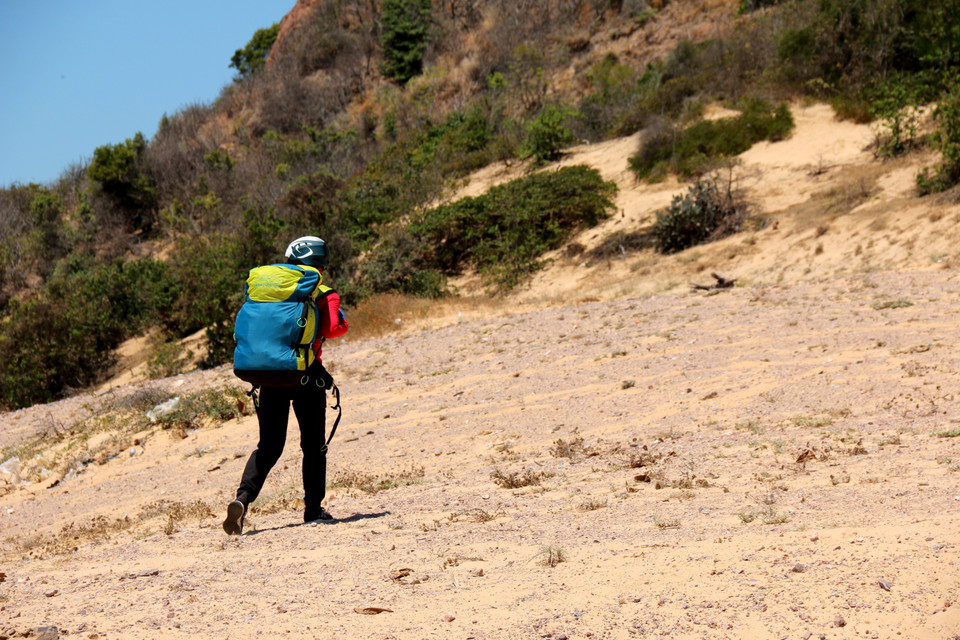 Hòn Hồng là một trong những địa điểm lí tưởng được nhiều người yêu thích trò dù lượn lựa chọn. Trong ảnh: Người chơi phải đi bộ di chuyển lên khu vực xuất phát trên núi tại Hòn Hồng thuộc địa phận xã Hòa Thắng, huyện Bắc Bình. (Ảnh: Nguyễn Thanh/TTXVN)