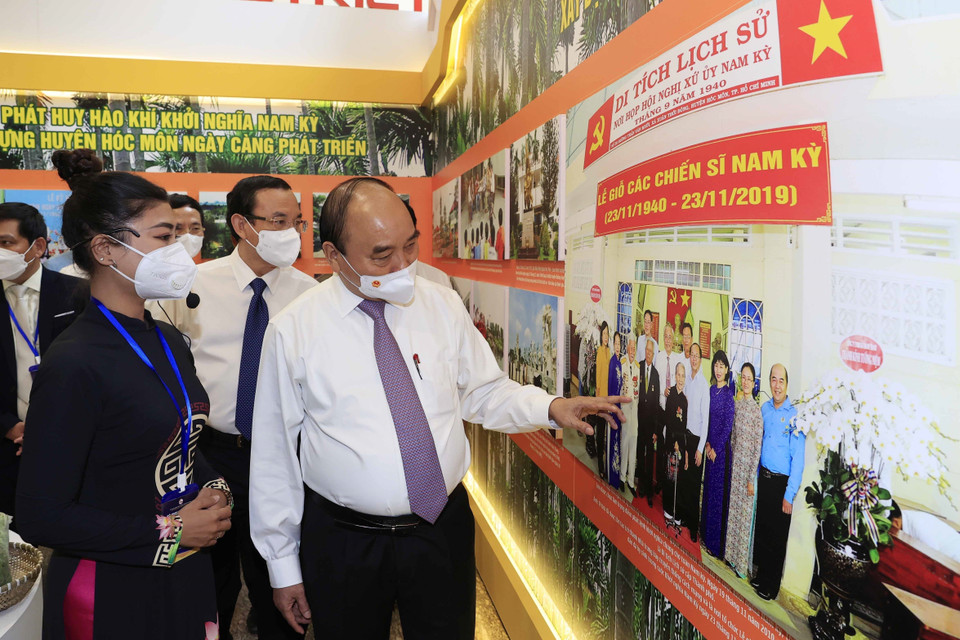 Hình ảnh Chủ tịch nước Nguyễn Xuân Phúc tham quan phòng truyền thống của huyện Hóc Môn. (Ảnh: Thống Nhất/TTXVN)