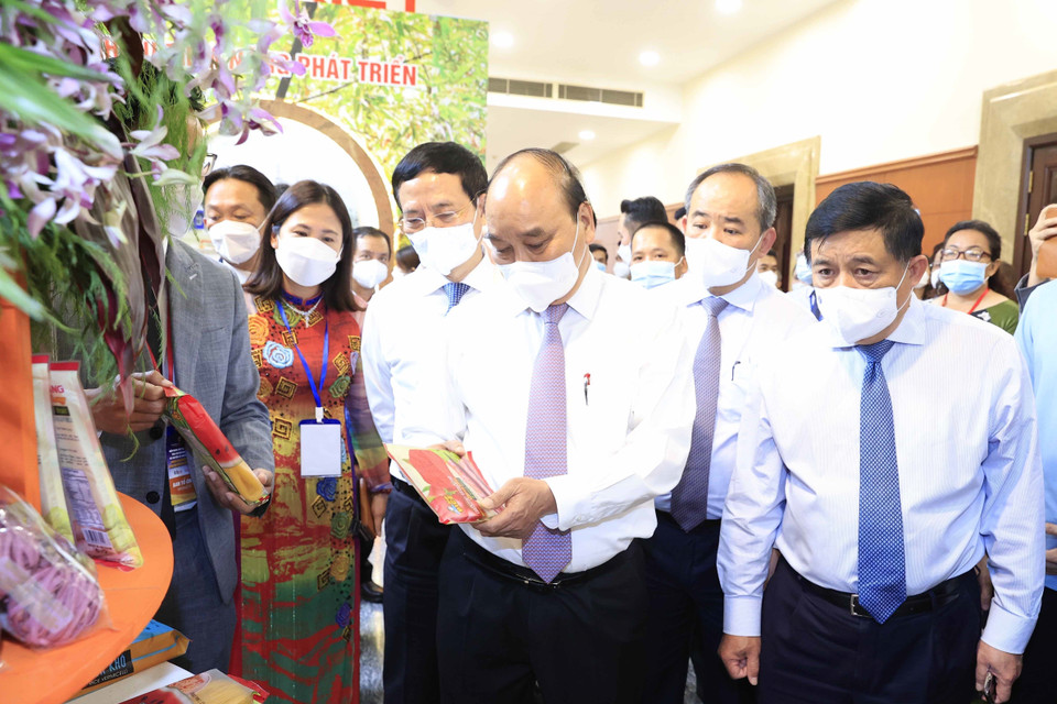 Chủ tịch nước Nguyễn Xuân Phúc thăm khu trưng bày các sản phẩm tiêu biểu của huyện Hóc Môn và Củ Chi. (Ảnh: Thống Nhất/TTXVN)