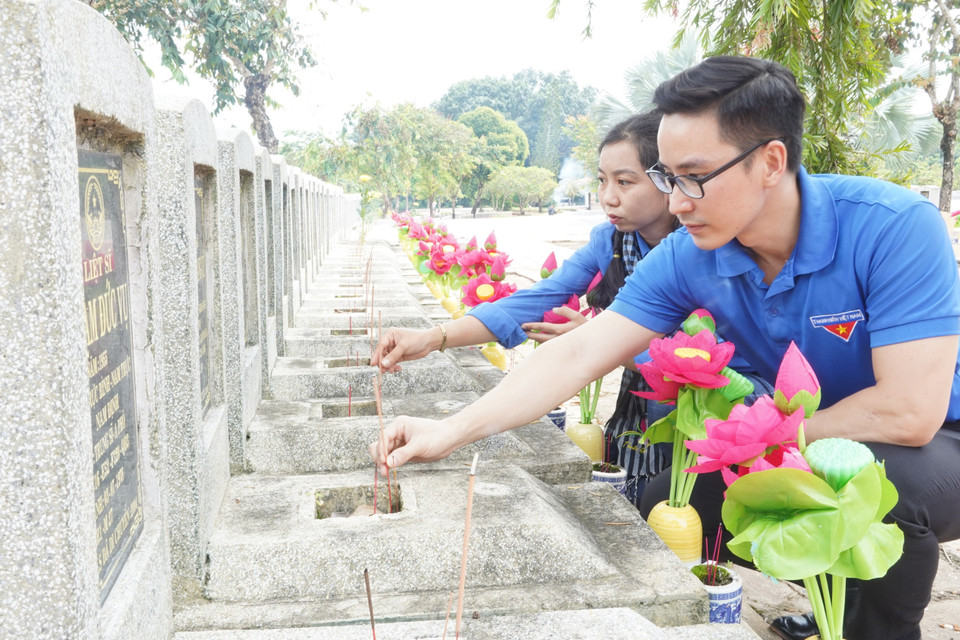 Đoàn Thanh niên Cơ quan Thông tấn xã Việt Nam khu vực phía Nam dâng hương tại mộ liệt sỹ thuộc Nghĩa trang Liệt sỹ Đồi 82 (huyện Tân Biên, tỉnh Tây Ninh). (Ảnh: Thanh Tân/TTXVN)