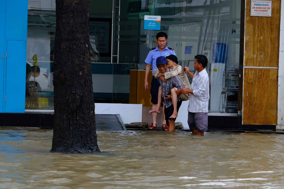 Một cụ bà được người thân cõng đi khám bệnh trên đường Trần Hưng Đạo, thành phố Cần Thơ. (Ảnh: Thanh Liêm/TTXVN)