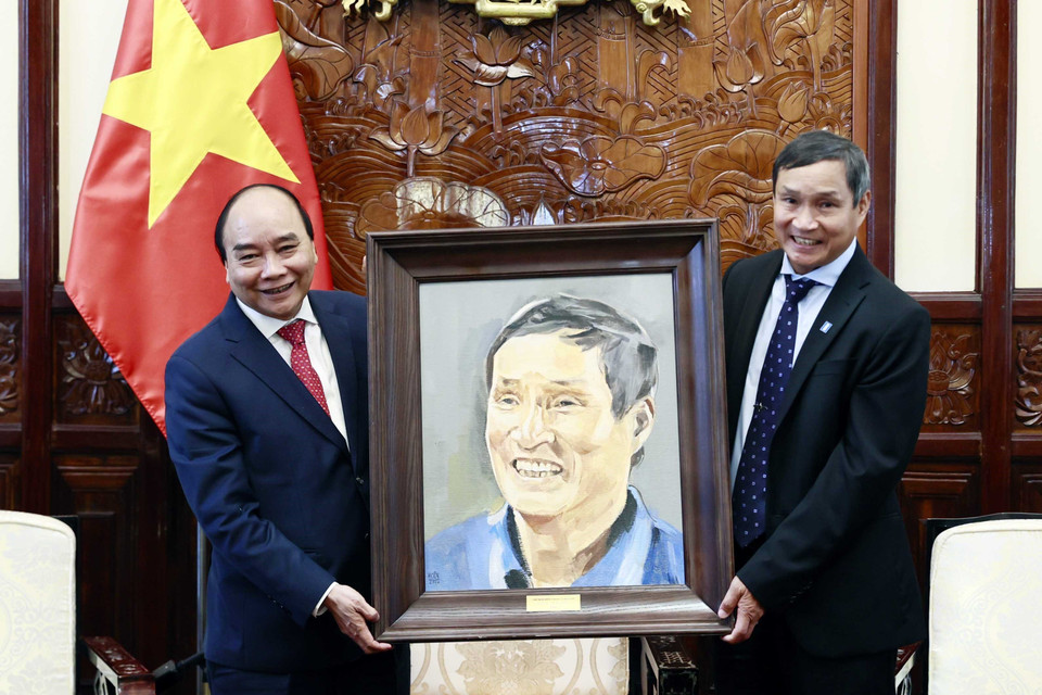 Chủ tịch nước Nguyễn Xuân Phúc tặng quà lưu niệm cho huấn luyện viên bóng đá nữ Mai Đức Chung. (Ảnh: Thống Nhất/TTXVN)