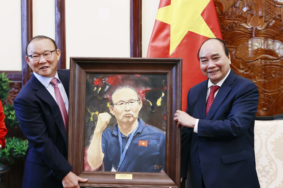 Chủ tịch nước Nguyễn Xuân Phúc tặng quà lưu niệm cho huấn luyện viên Park Hang-seo. (Ảnh: Thống Nhất/TTXVN)