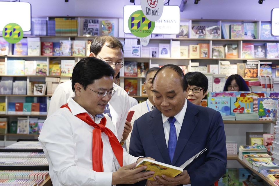 Hình ảnh Chủ tịch nước Nguyễn Xuân Phúc và các đại biểu tham quan trưng bày Dấu ấn 65 năm Nhà xuất bản Kim Đồng. (Ảnh: Thống Nhất/TTXVN)