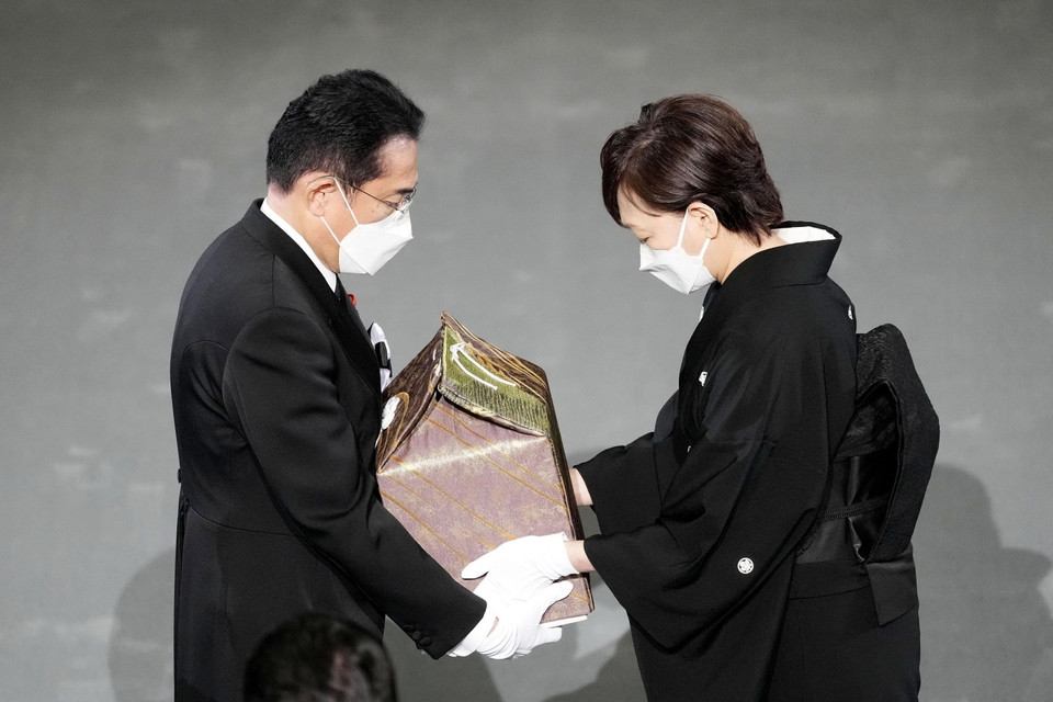 Phu nhân cố Thủ tướng Nhật Bản Abe Shinzo, bà Abe Akie (phải) trao hũ tro cốt của chồng cho Thủ tướng Kishida Fumio trong Lễ quốc tang tại Tokyo ngày 27/9. (Ảnh: AFP/TTXVN)